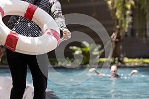Person hand holding ringbuoy to rescue drowning in dangerous situation on summer vacation,asian child girl struggling in water,