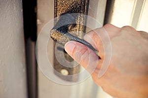 Person hand opening a gate door with a doorknob