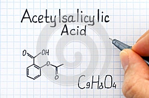 Person hand with pen writing chemical formula of Acetylsalicylic Acid. photo