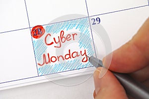 Person hand with pen writing Cyber Monday in calendar