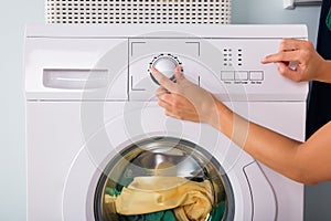 Person Hand Pressing Button Of Washing Machine