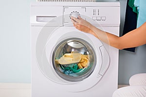 Person Hand Pressing Button Of Washing Machine