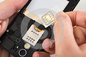 Person hand with sim card and mobile phone