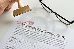 Person hand with stamp and approved mark on mortgage application