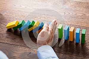 Person Hand Stopping Dominoes photo