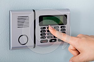 Person Hand Using Home Security Alarm