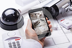 Person Hand Using Home Security System On Mobilephone