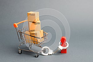 A person is handcuffed to a bunch of boxes a on a supermarket cart. The concept of dependence on shopping and buying new things.