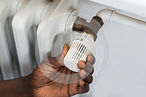 Person Hands Adjusting Thermostat Radiator