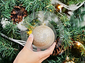 Person, hands and ball with Christmas tree for decoration, festive or holiday season at home. Closeup of ornament