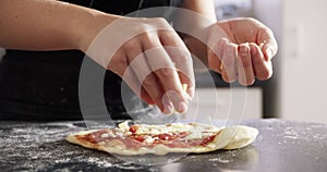 Person, hands and cheese on pizza dough for prepare raw ingredient for baking, production or process. Chef, sprinkle and