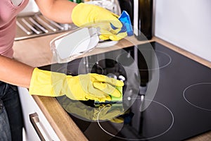 Person Hands Cleaning Induction Stove In Kitchen photo