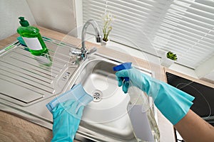 Person hands cleaning kitchen sink