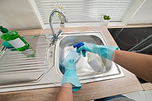 Person hands cleaning kitchen sink