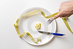 person hands with fork and knife eat small portion of food. anorexia b