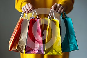 Female hands holding and showing colorful shopping bags