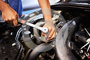 Person, hands and mechanic with spanner for fixing engine in workshop for motor maintenance and service. Industry