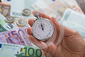 Person Hands With Stopwatch Over Money