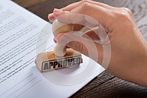 Person Hands Using Stamper On Document