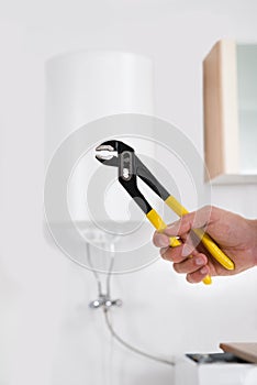 Person Hands With Wrench In Front Of Electric Boiler