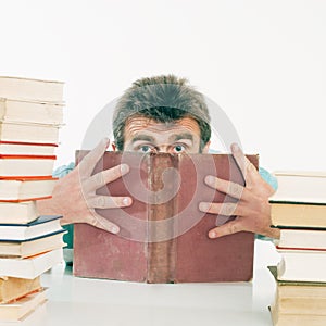 The person hides the face behind the old book.