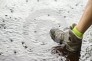 Person in hiking boots walking on water in the rain