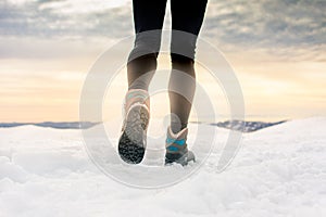 Person hiking on the mountaintop covered with snow