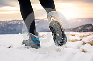 Person hiking on the mountaintop covered with snow