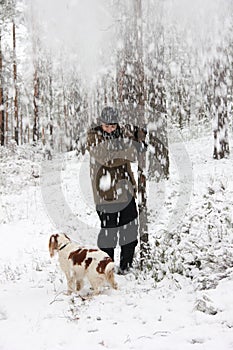 Person and his dog play with snow