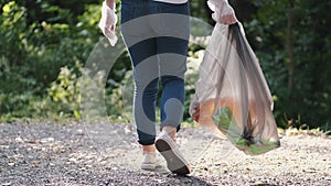 Person holding bag with garbage after cleaning forest