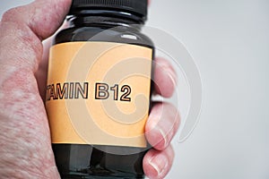 Person holding Bottle of Vitamin B12