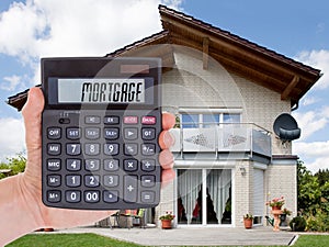 Person Holding Calculator Outside The House