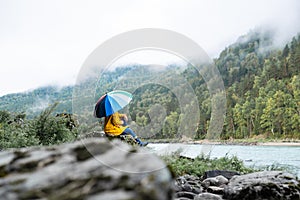 Person holding a colored umbrella. Rainy and wet weather.