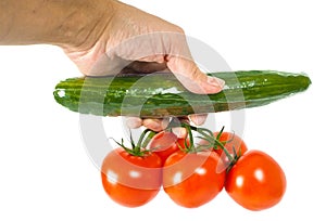 Person holding a cucumber and a bunch of tomatoes