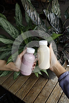 a person holding a cup of water next to a plant