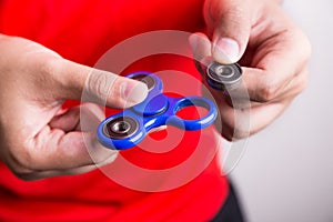 Person holding dislodged weight from fidget spinner, dangerous f