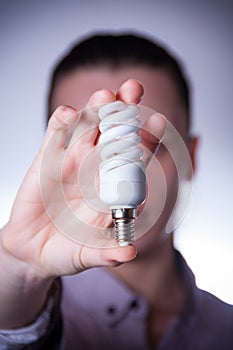 Person holding energy saving lamp