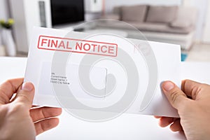 Person Holding Final Notice Envelope