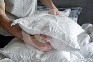 Person holding a fluffy pillow, conveying concepts of comfort and home preparation for restful environment photo