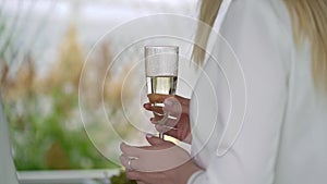 Person holding glass of wine or champagne or other alcohol drink in hand at the party.