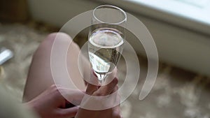 Person holding glass of wine or champagne or other alcohol drink in hand at the party.