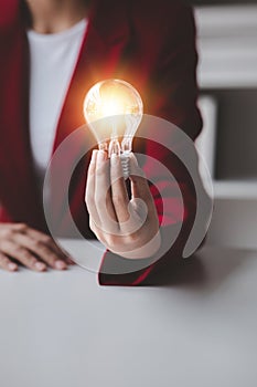 Person holding glowing lamp, Creative new idea. Innovation, brainstorming, strategizing to make the business grow and be