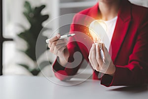 Person holding glowing lamp, Creative new idea. Innovation, brainstorming, strategizing to make the business grow and be