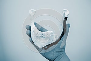 Person holding in hand facial mandibular endoprosthese printed metal 3D printer photo