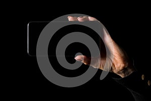 Person holding in hand mobile phone in horizontal orientation