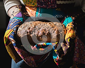 Person Holding a Loaf of Seed Bread in a Pan