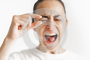 Person holding micro chip for implant with defocused screaming face. Chipization