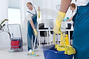 Person holding a mop pail photo