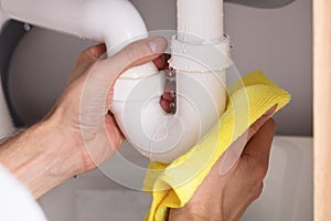 Person Holding Napkin Under Sink Pipe Leakage