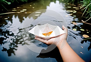 a person holding a paper boat on the water